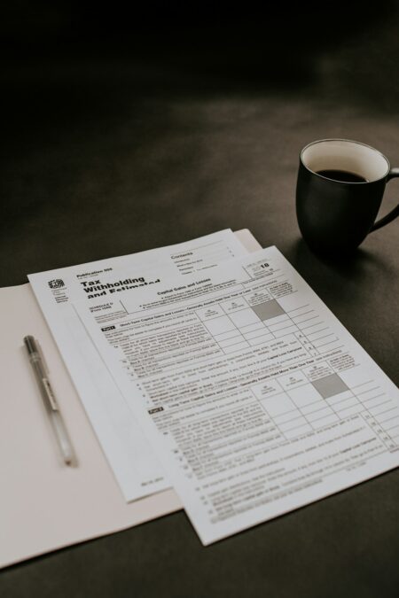IRS tax documentation, calculator, and statutory deductible guidelines on desktop
