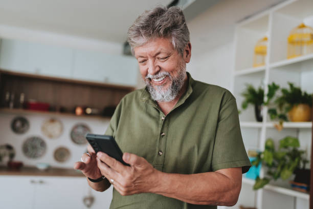 Older man looking at his smartphone at home
