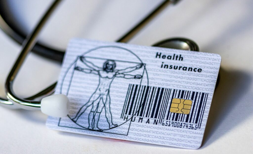Health insurance card and stethoscope representing a health plan comparison