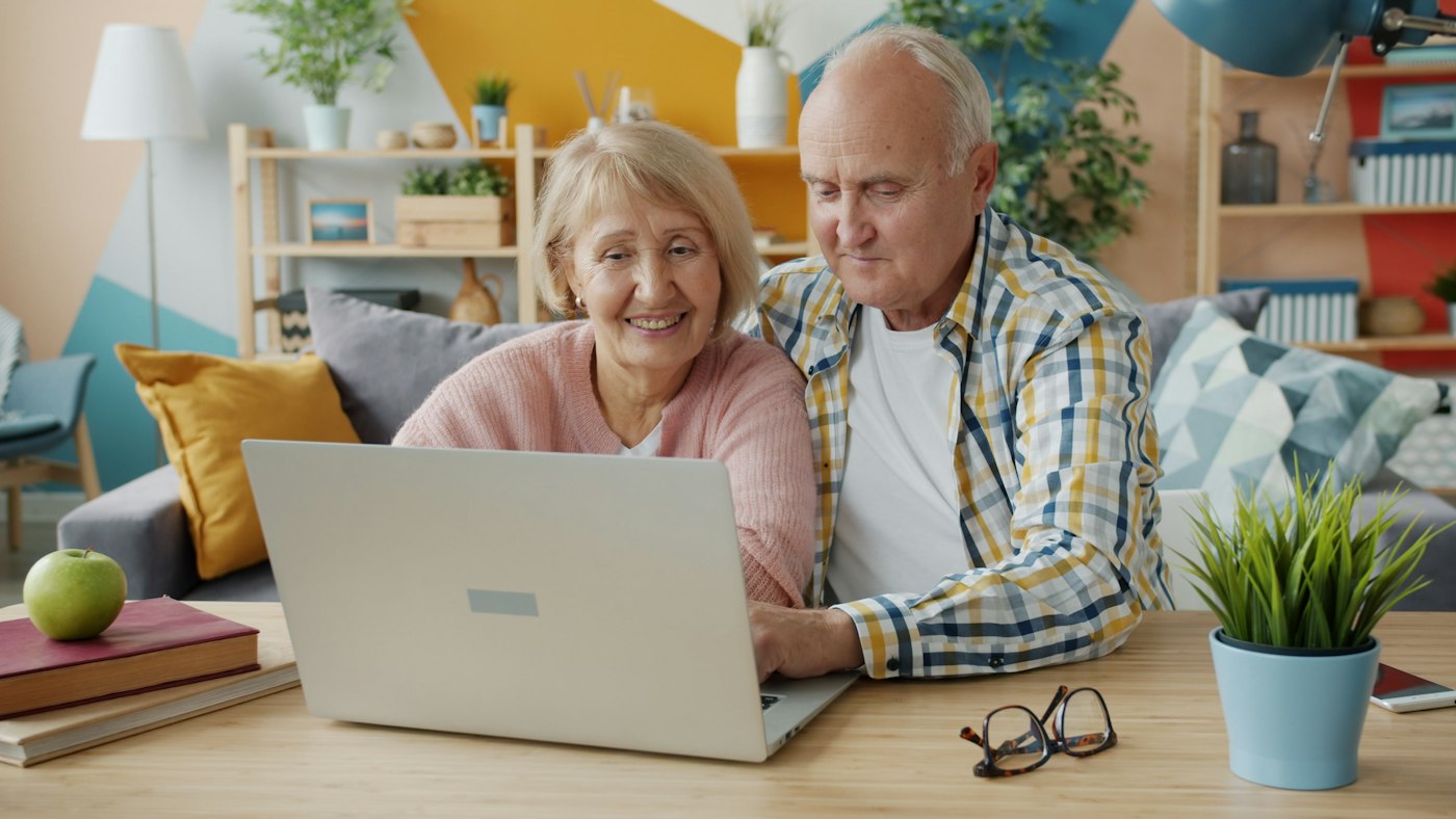Older couple comparing plans on a computer at home