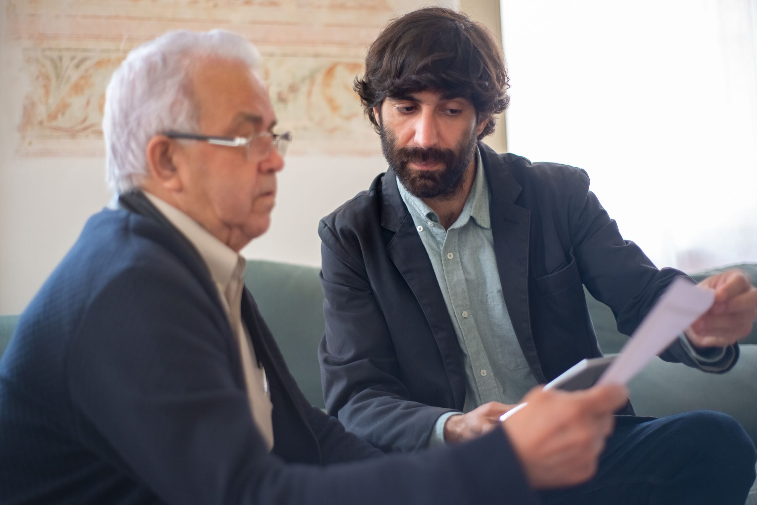 An advisor showing an elderly client a document and explaining it