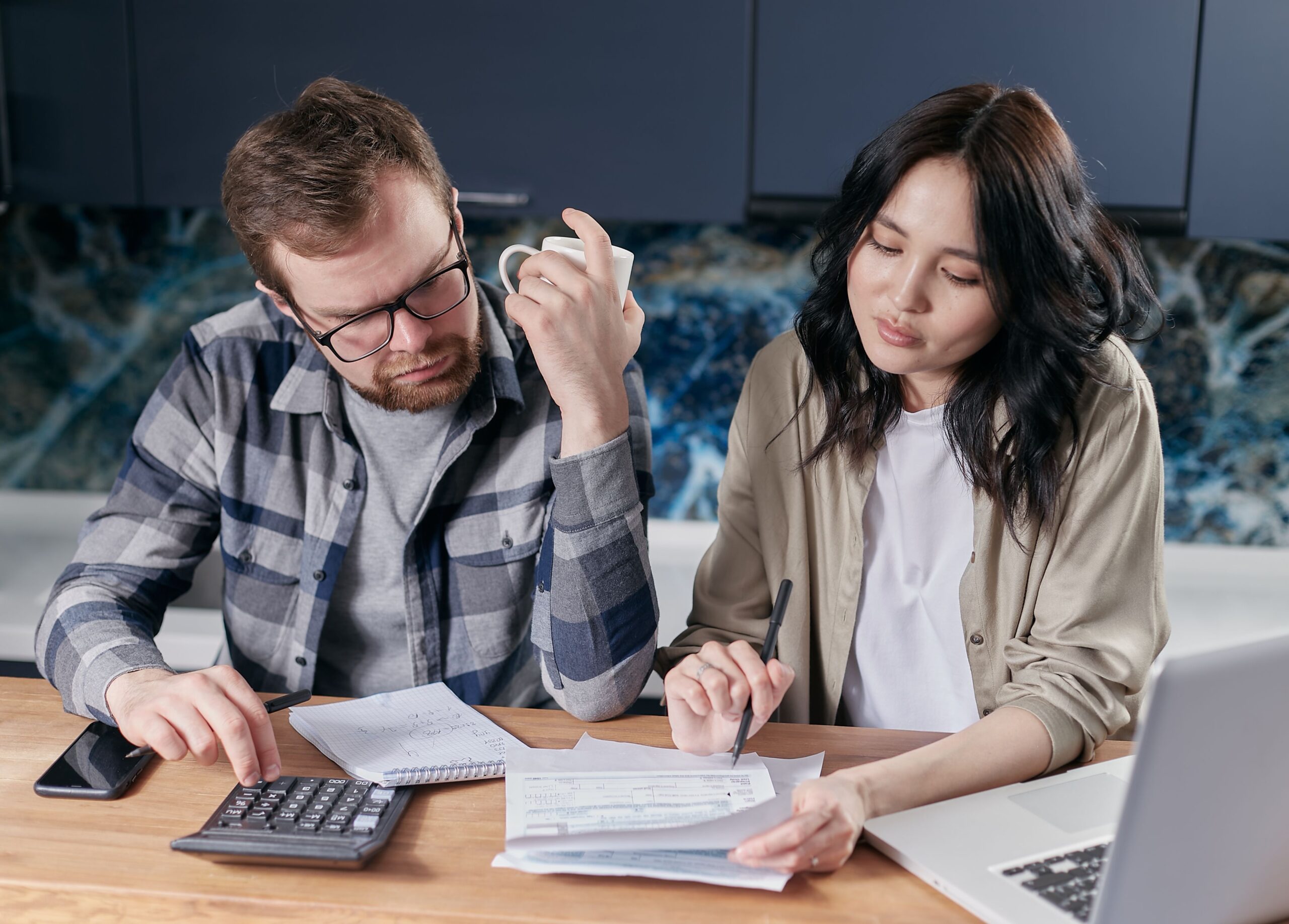 A couple sitting together at a table looking over their bills