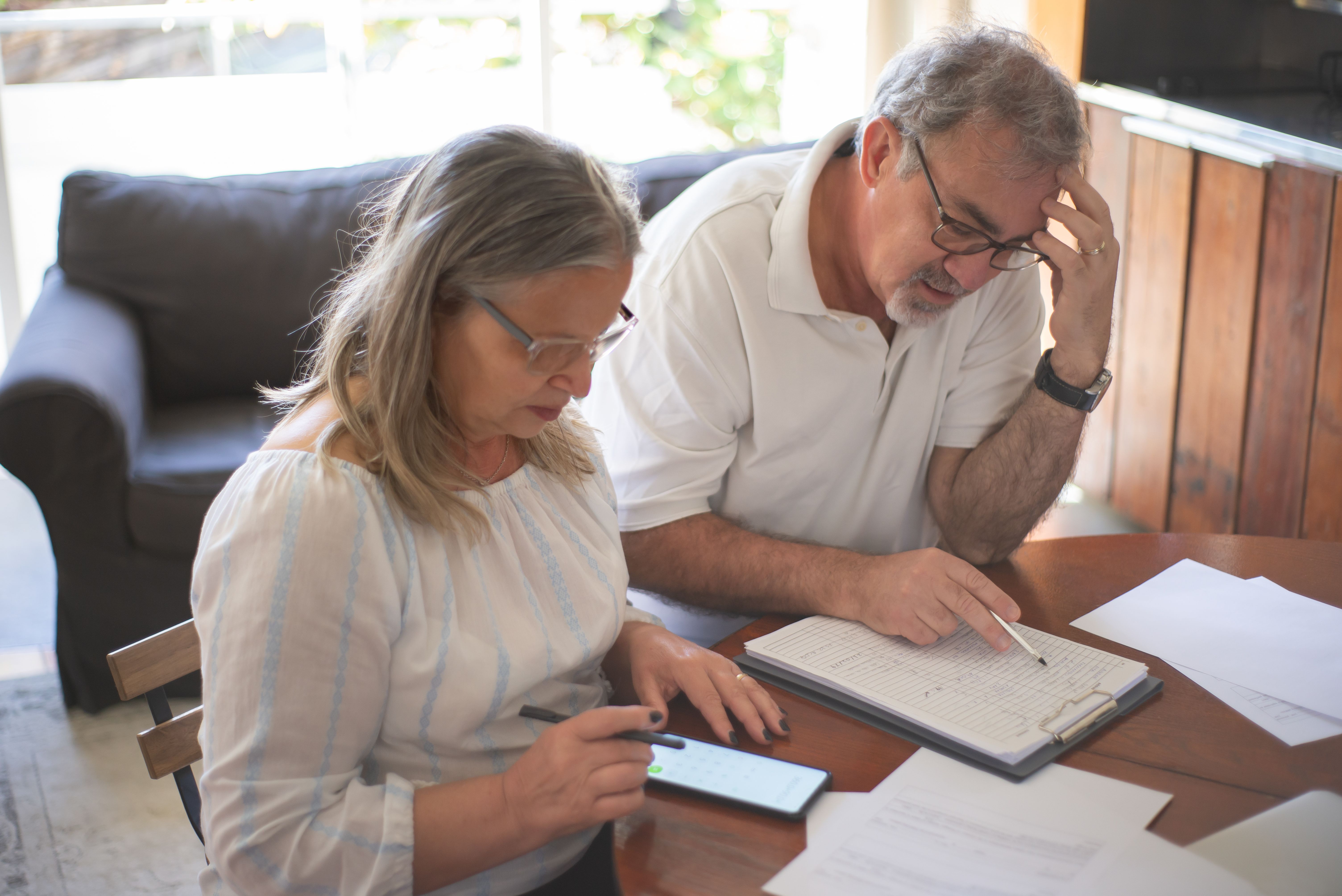 Older couple going through documents with a smartphone