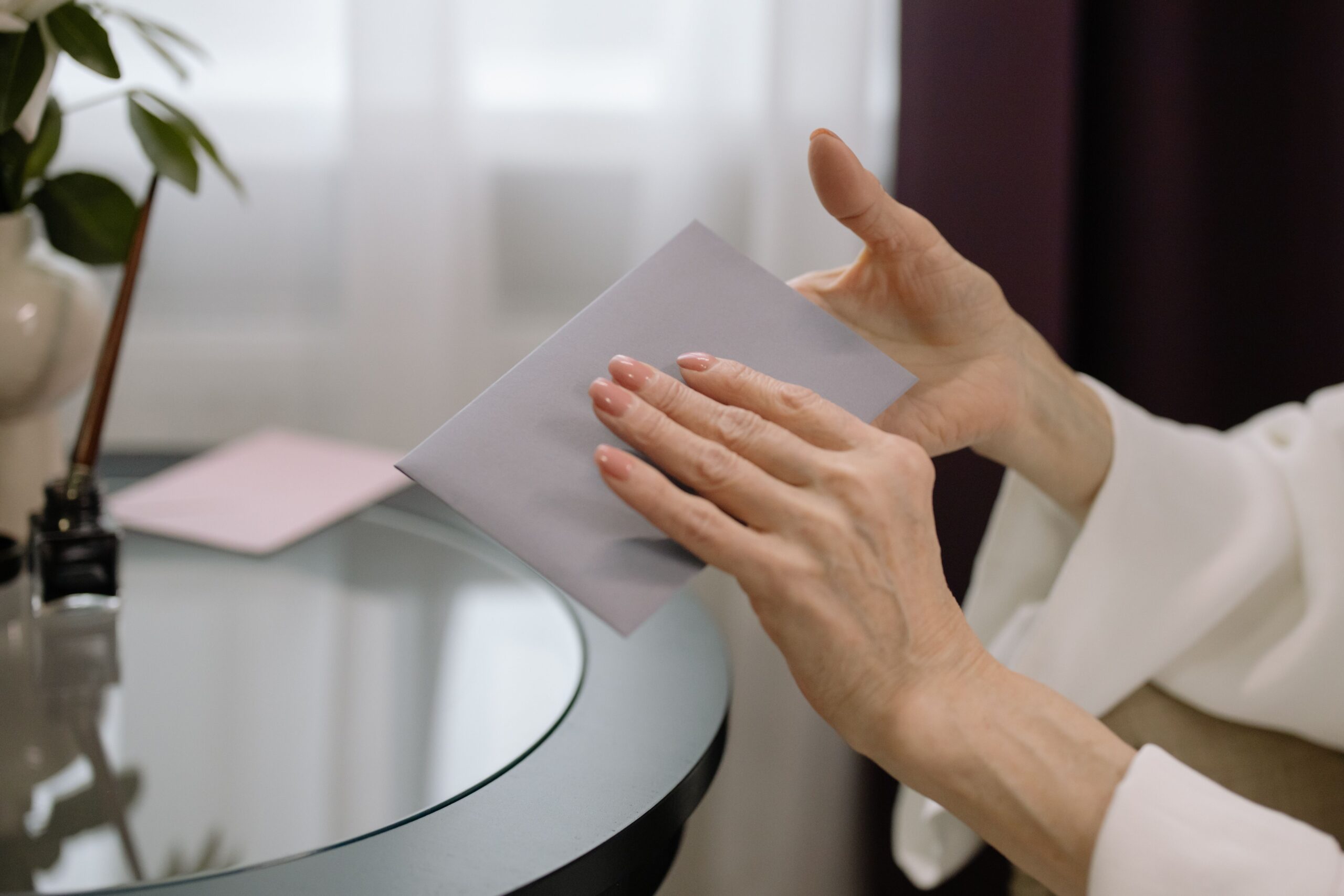 A person holding a letter envelope that has just arrived in the mail
