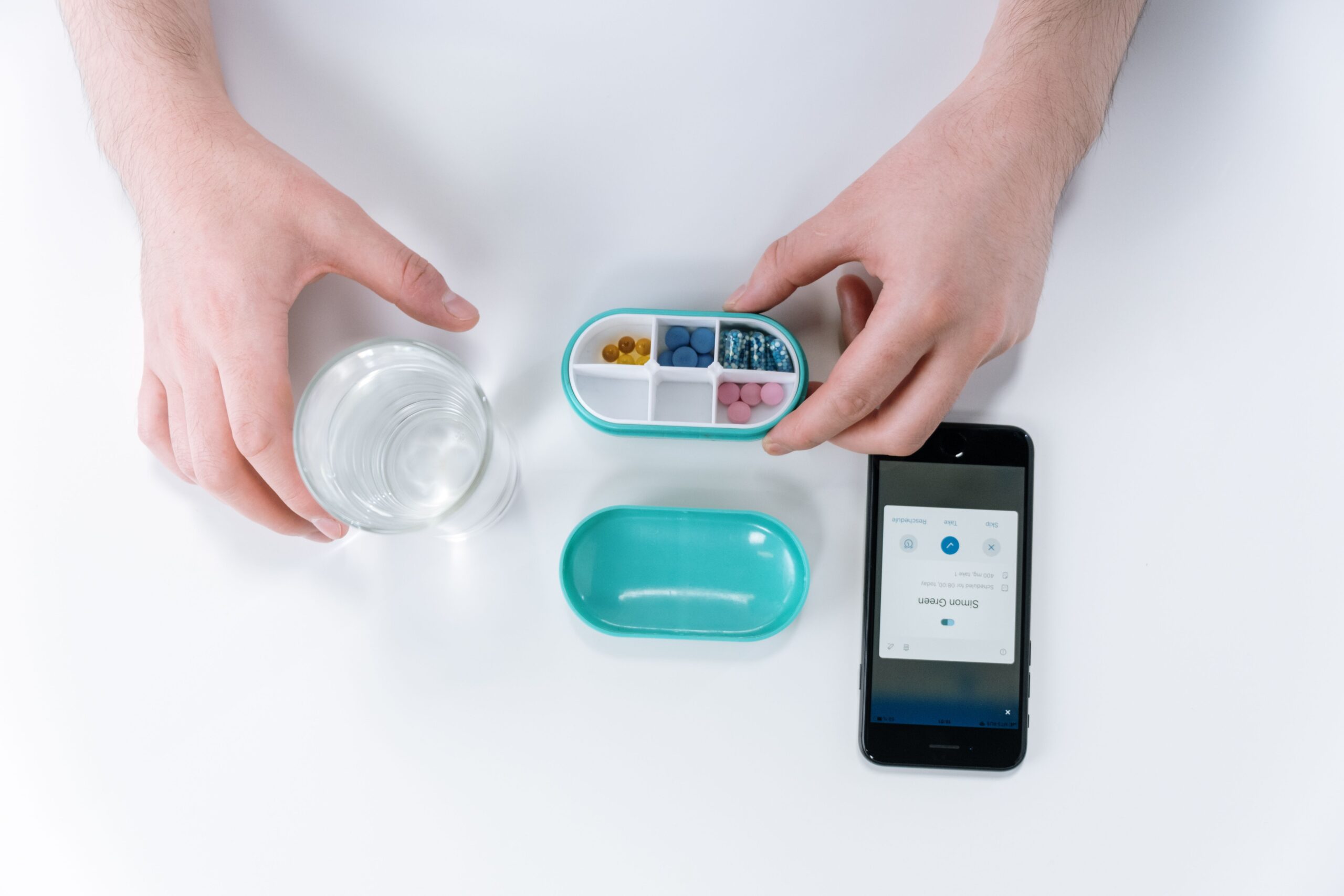 A person holding a weekly pill box for daily medication