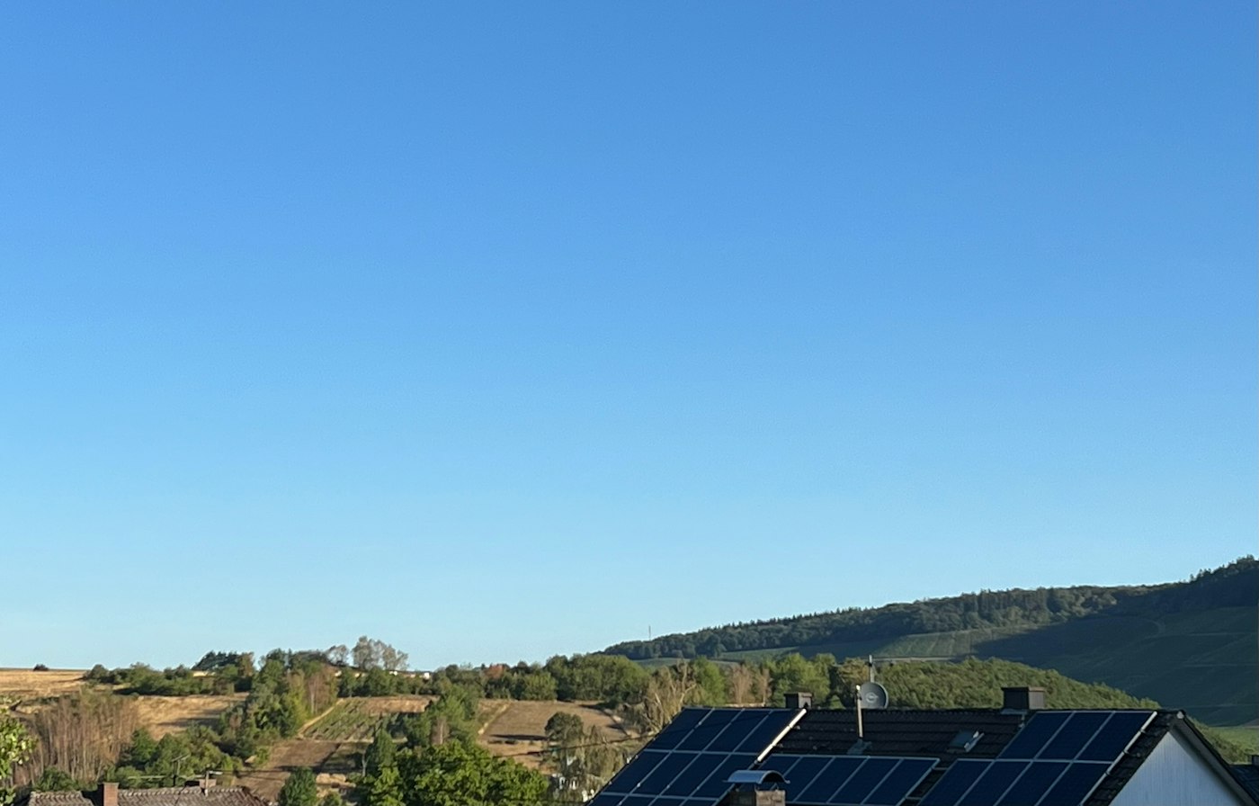 Solar panels on a house roof under a clear blue sky